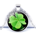 Gros plan d'un collier trèfle à quatre feuilles avec pendentif en verre serti - Trèfle sur Fond Noir(JY003238-10)