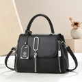 Black lychee leather handbag with silver metallic tassel pendant and sturdy top handles - Black