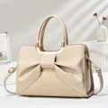 Close-up of beige shoulder bag featuring bow pleated design and crocodile pattern base - Khaki