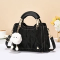Modern black handbag with white contrast stitching and a cute plush monster keychain - Black