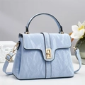 Detail of light blue textured handbag with gold lock and marble-effect glossy finish - Blue