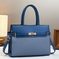 Detailed view of the navy blue leather and woven fabric tote with a gold twist-lock closure - Blue