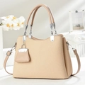 Borsa beige con trama a coste, doppi manici e mini ciondolo in un ambiente minimalista - Albicocca
