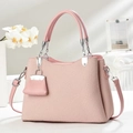 Dettaglio della borsa rosa a trama intrecciata con mini ciondolo e sfondo di gigli - Rosa
