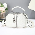 Detail of white crocodile pattern handbag with silver bear pendant and woven strap - White