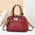 Dettaglio della borsa patchwork rosso e marrone con texture stropicciata e metallo - Borgogna