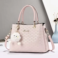 Detailansicht der rosa Tragetasche mit Logo-Prints, Gold-Hardware und flauschigem Anhänger - Rosa