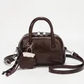 Dunkelbraune Boston-Handtasche aus Öl-Wachs-Leder mit Sternanhänger und Schultergurt - Braun