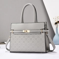 Détail d'un sac à main gris en similicuir avec motif gaufré et fermoir doré tournant - Gris