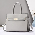Detail of grey lychee leather texture with golden twist lock on stylish handbag - Gray