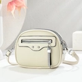 Close-up of cream crossbody bag featuring silver rivets and mesh tassel zip detail - Off White