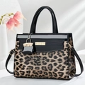 Détail du sac léopard avec garniture en cuir verni noir et boucle dorée chic - Khaki Clair