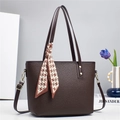 Dettaglio borsa a secchiello in pelle marrone con trama litchi e foulard pied-de-poule - caffè