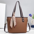 Close-up of brown litchi leather bucket bag featuring a decorative houndstooth scarf handle - Brown
