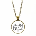 Dettaglio della collana in bronzo con scritta Thankful & Blessed su sfondo bianco - Bronzo