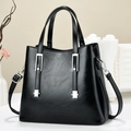 Schwarze Handtasche aus glänzendem Kunstleder mit silbernen Akzenten und Schultergurt - Schwarz