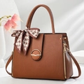 Detail view of brown striped PU leather handbag with gold ring and houndstooth scarf - Earthy Yellow