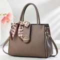 Close-up of brown striped handbag with gold buckle and chic houndstooth silk scarf detail - Khaki
