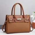 Detail einer braunen Tasche aus strukturiertem Webstoff mit Lederbesatz und Goldverschluss - Erdgelb