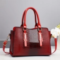 Detail of red crocodile embossed tote with gold hardware and removable shoulder strap - Red