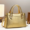 Detailed close-up of golden crocodile pattern handbag with luxury metal hardware and strap - L30 W12 H18 / Gold