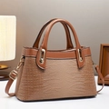 Detail of brown crocodile pattern handbag with gold hardware in cozy home setting - L30 W12 H18 / Khaki