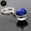 Macro detail of Leo zodiac luminous glass ball keychain with polished silver metal ring - Leo