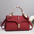 Detail of red crossbody bag with textured weave and silk scarf wrapped around the handle - Red