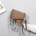 Close-up of khaki envelope bag featuring wave embroidery and jacquard shoulder strap - Brown