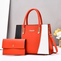 Détail du sac cabas bicolore avec coutures en zigzag et logo de marque en métal - Rouge