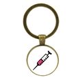 Macro detail of bronze nurse keychain featuring a syringe graphic in circular glass dome - Pink Liquid Syringe (JY005474-9)