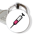 Close-up of metal keychain with syringe illustration and silver key accessory - Pink Smiling Syringe (JY005477-9)