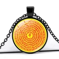 Macro view of a black round pendant necklace featuring religious Sanskrit symbols - Yellow Base Concentric Red Mantra (JY005539-3)
