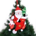 Detail of wooden Santa Claus ornament with small Christmas tree and red hanging string - Santa Claus Pendant