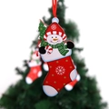Macro shot of a wooden snowman ornament in a red Christmas stocking with a red ribbon - Snowman Style