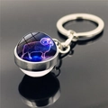 Detail of Aries constellation glass ball keychain with silver metal base and star design - Aries
