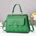 Detail van smaragdgroene gewatteerde handtas met goudkleurige hardware en textuur - Groen