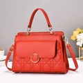 Detail of red quilted handbag with gold ring clasp and accordion-style side structure - Red