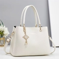 Elegante borsa a mano in pelle beige con catena dorata e ciondolo di perle raffinato - Bianco