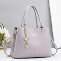 Detail of lavender litchi pattern handbag with gold hardware and tassel charm - Gray