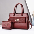 Close-up of a stylish burgundy tote and matching chain bag with gold interlocking buckles - Red