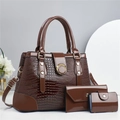 Vue détaillée de la texture lézard marron foncé et boucle dorée sur les sacs à main de luxe - Café