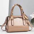 Detail van handtas met reliëf, zijden sjaal om de handvatten en goudkleurige metalen accenten - Khaki