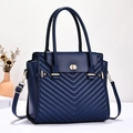 Detailed view of deep blue chevron quilted tote bag with golden twist-lock clasp and strap - L30xW12xH26 / Blue