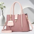 Borsa tote rosa a righe con chiusura dorata e mini ciondolo in un ambiente elegante - Rosa