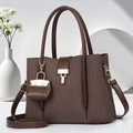 Borsa tote marrone a righe con trama a pieghe e tracolla regolabile in un ambiente minimal - caffè