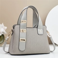 Detail of light grey pleated handbag with adjustable strap and golden metal hardware buckles - Gray