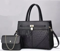 Detail of black patchwork handbag featuring ostrich and snakeskin textures with gold hardware - Black