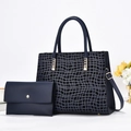 Dettaglio della borsa tote blu navy con motivo a pietra e clutch con hardware dorato - Blu