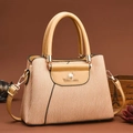 Dettaglio borsa beige testurizzata con cuciture ondulate e finiture dorate su sfondo scuro - L25 P12 A18 / Beige